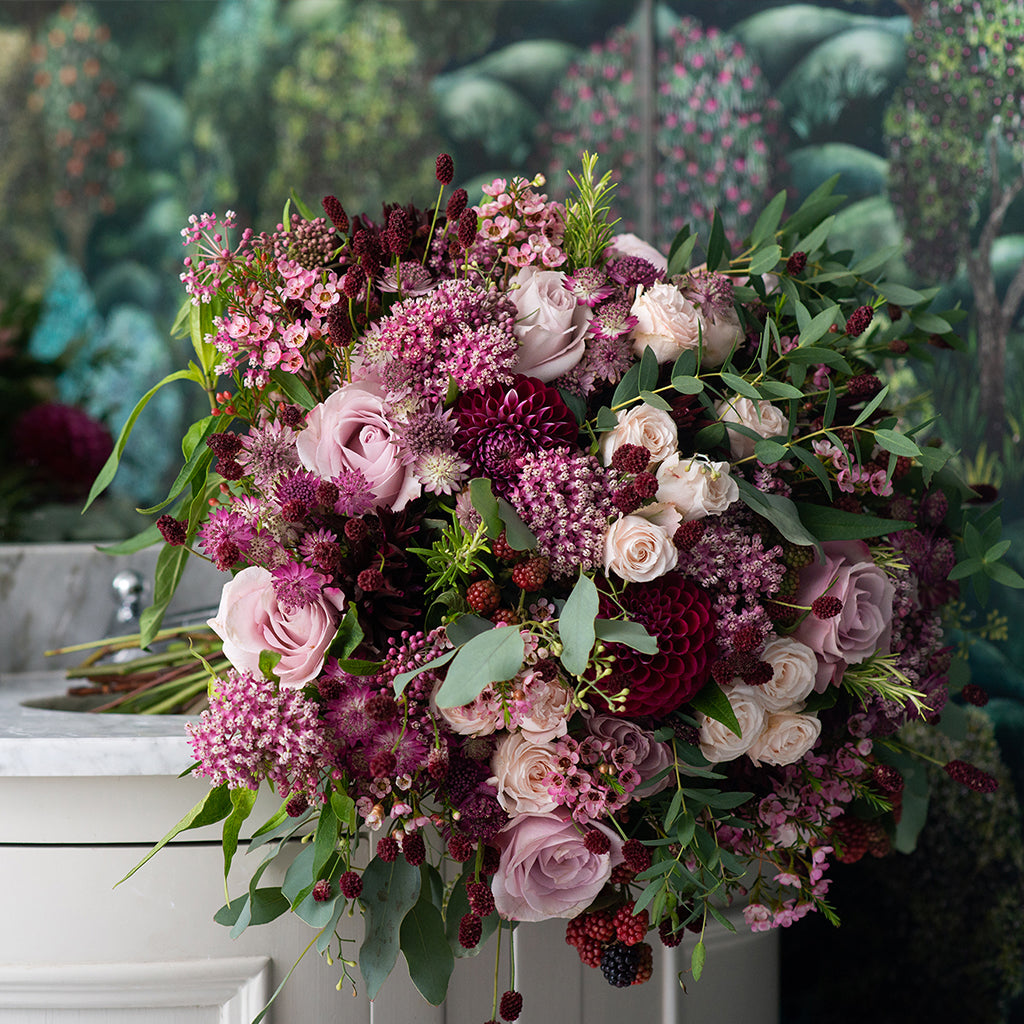 Wild at Heart Midnight Meadow Bouquet, combining burgundy dahlia, soft pink roses, astrantia, pink wax flower, raspberries, sangrisorbia and achillea